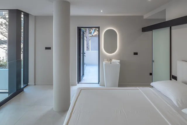 Bedroom with terrace access and an illuminated mirror