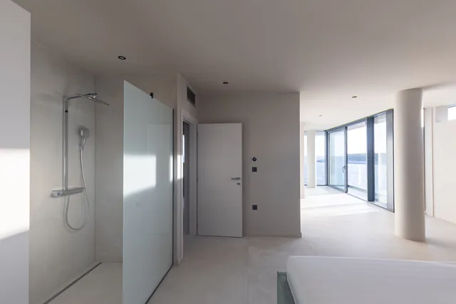 En-suite bedroom with floor-to-ceiling sea views